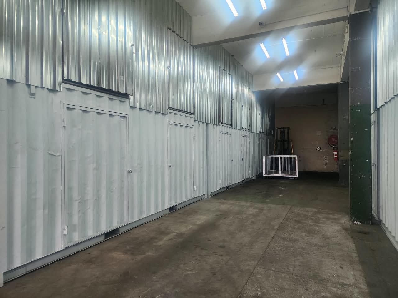 Indoor corridor lined with white storage unit doors at store fast, offering self storage units in cape town.